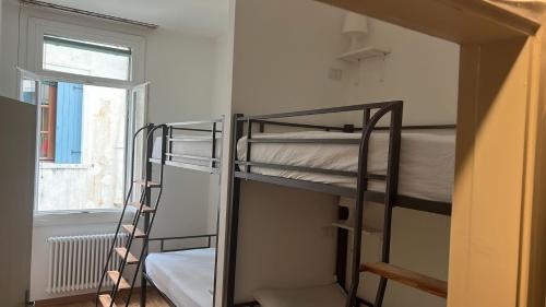 two bunk beds in a room with a window at FORESTERIA SOCIALE VENICE SAN MARCO by NEW GENERATION HOSTEL in Venice