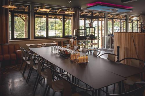 een grote tafel in een kamer met stoelen en ramen bij Boris & Barney in Mechelen