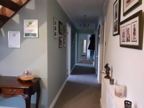 a hallway in a house with a table and pictures on the walls at The Ring Farmhouse in Birr