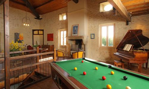 a living room with a pool table and a piano at Le Mas de la Roche in Montbrison-sur-Lez