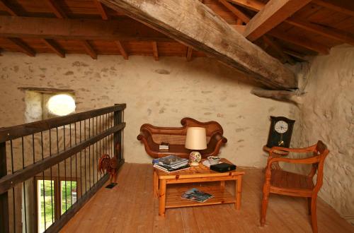 a room with a table and a chair and a clock at Le Mas de la Roche in Montbrison-sur-Lez