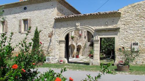 an entrance to a stone building with an arch at Le Mas de la Roche in Montbrison-sur-Lez