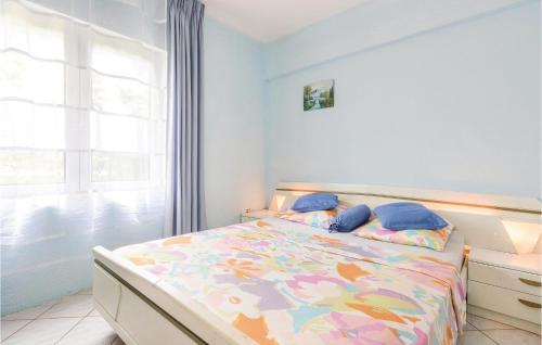 a bedroom with a bed with a colorful comforter and a window at 4 Bedroom Beautiful Apartment In Stinjan in Štinjan