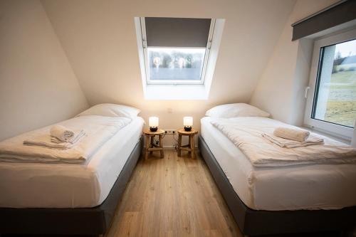 two twin beds in a room with a window at Q-Stall am Poppenberg in Brilon