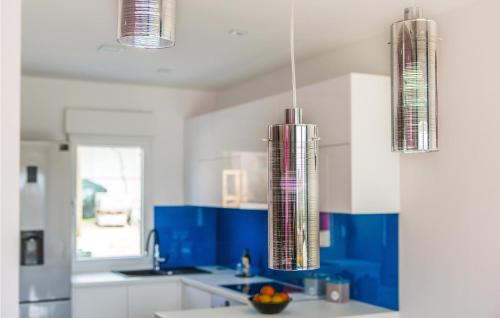 uma cozinha com armários e luzes azuis e brancas em Nice Home In Kastel Kambelovac With Heated Swimming Pool em Kaštela