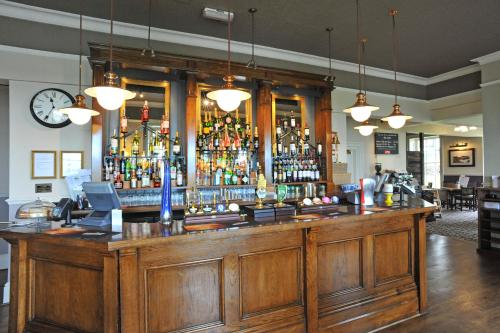 a large wooden bar in a restaurant at Royal Hotel by Greene King Inns in Ross on Wye