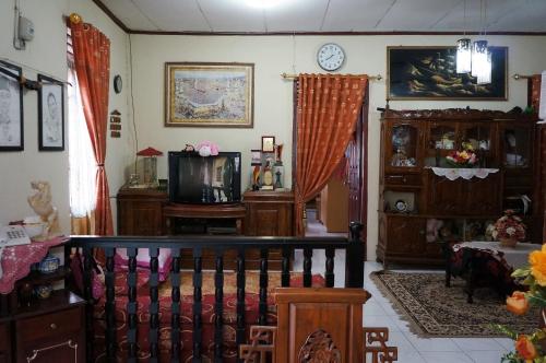 a living room with a crib and a tv at Cendana Homestay in Sawahlunto