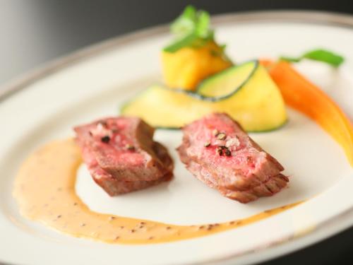 a plate of food with meat and vegetables on it at Rako Hananoi Hotel in Suwa