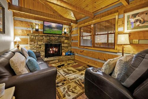 a living room with leather chairs and a fireplace at The Robins Nest with hot tub in Pigeon Forge