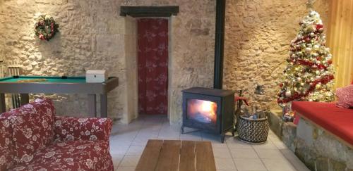 a living room with a fireplace and a christmas tree at MOULIN DE L'HOSTE in Larzac