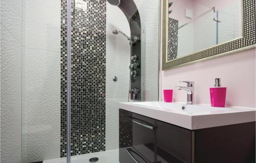 uma casa de banho com um lavatório e um chuveiro em 3 Bedroom Cozy Apartment In Kastel Stafilic em Kaštela