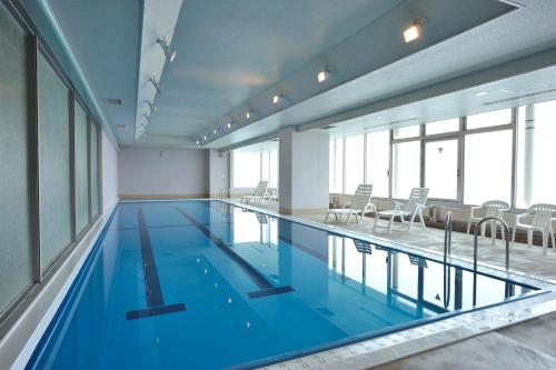 uma grande piscina com água azul num edifício em Rako Hananoi Hotel em Suwa