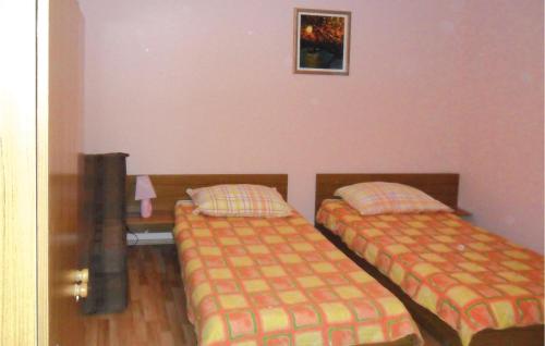 sypialnia z 2 łóżkami i stołem z lampką w obiekcie Lovely Apartment In Orebic With Kitchen w Orebiciu