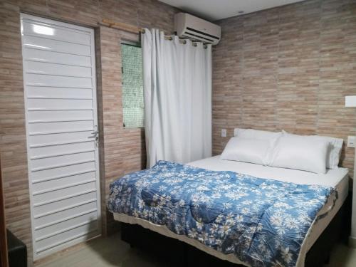 Schlafzimmer mit einem Bett und einem Fenster in der Unterkunft Flat Recanto do Sertão in Piranhas