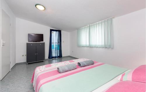 a bedroom with a large bed and a tv at Nice Apartment In Stinjan With Kitchen in Štinjan