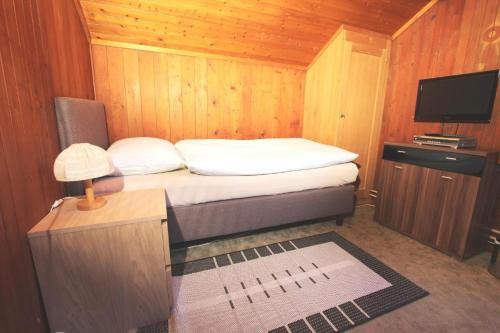 a small bedroom with a bed and a television at Hotel-Restaurant Alpina in Innertkirchen