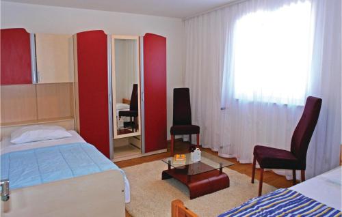 a bedroom with a bed and a chair and a mirror at 3 Bedroom Beautiful Apartment In Kastel Novi in Kastel Novi