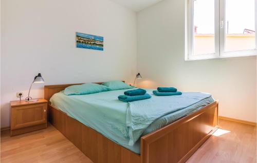 a bedroom with a bed with two blue towels on it at Amazing Apartment In Medulin With Kitchen in Medulin
