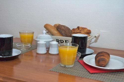 a table with a breakfast of bread and orange juice at De Herberg in Renesse