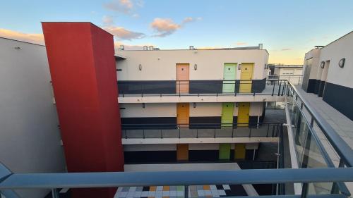 - une vue depuis le balcon d'un bâtiment avec des portes colorées dans l'établissement Logesty Studio Cosy316, à Perpignan