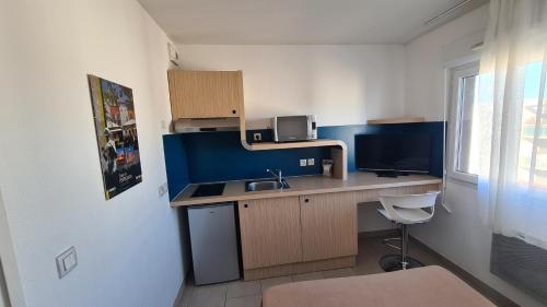 a small kitchen with a sink and a desk at Logesty Studio Cosy316 in Perpignan