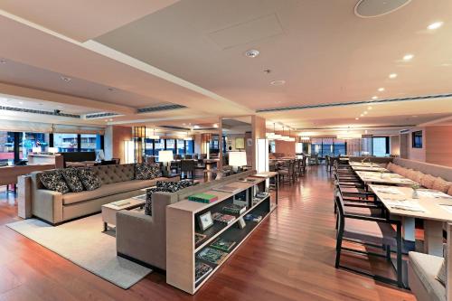 a restaurant with couches and tables in a building at Hotel COZZI Zhongxiao Taipei in Taipei