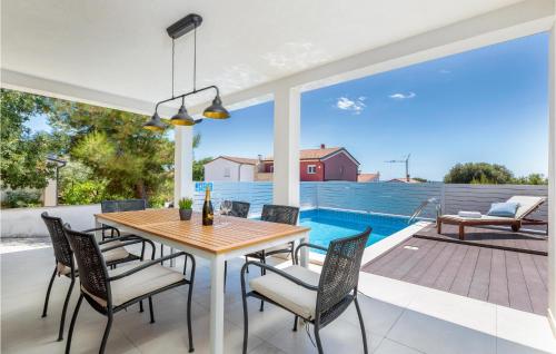 a patio with a table and chairs and a pool at Beautiful Home In Betiga With Wifi in Barbariga