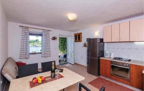 a kitchen and living room with a table and a refrigerator at Apartment Banici Ii in Slano