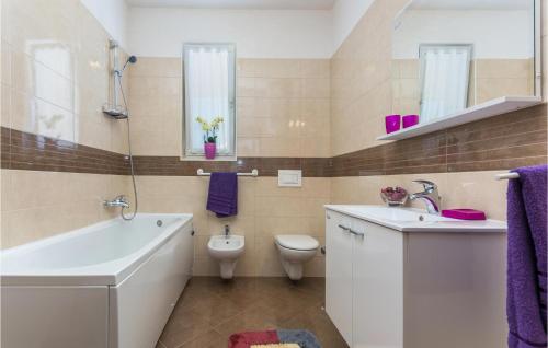 y baño con bañera, aseo y lavamanos. en Awesome Apartment In Novigrad With 2 Bedrooms And Wifi, en Novigrad Istria