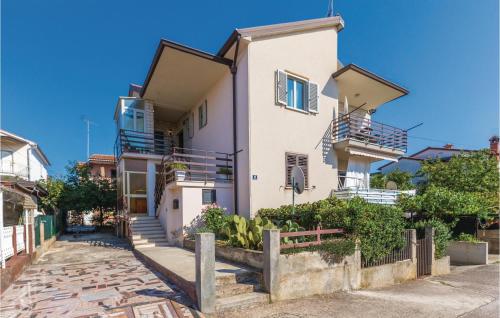 biały dom ze schodami i balkonami na ulicy w obiekcie Amazing Apartment In Novigrad With Wifi w mieście Novigrad