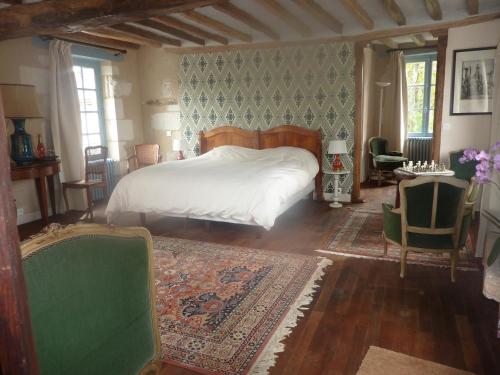 1 dormitorio con 1 cama, mesa y sillas en Les Douves, en Onzain