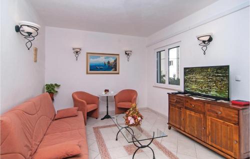 a living room with a couch and a flat screen tv at Holiday Home Supetar 98 With Game Room in Supetar