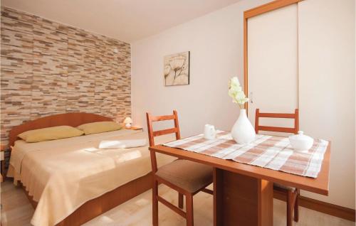 ein Schlafzimmer mit einem Bett und einem Holztisch mit einem Tisch in der Unterkunft Nice Apartment In Raslina With House Sea View in Raslina