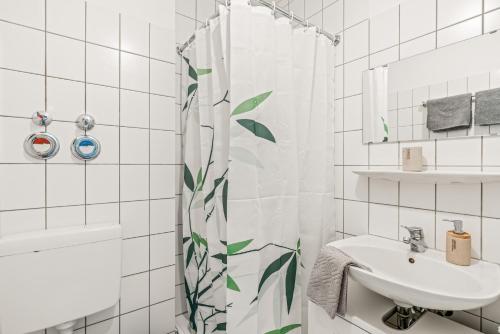 Un baño con lavabo y cortina de ducha. en CASSEL LOFTS - Stylisches Dschungel-Studio nähe Uni & Klinikum, en Kassel