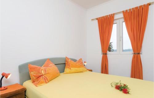 - une chambre avec un lit doté d'oreillers orange et une fenêtre dans l'établissement Amazing Apartment In Orebic With 1 Bedrooms And Wifi, à Orebić