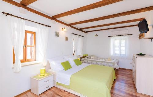 a white bedroom with a green bed and a television at Cozy Home In Slano With Wifi in Slano