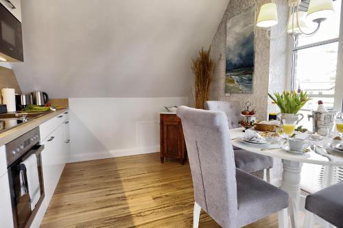 a kitchen with a white table and chairs in a room at Ostseerauschen in Zingst