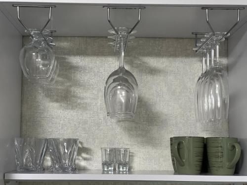 four glass bulbs hanging on a shelf with glasses at Kharkovlux in Kharkiv