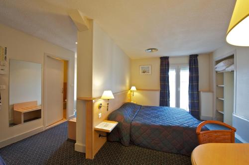 Postel nebo postele na pokoji v ubytování Hotel Le Bourbon Pau Centre