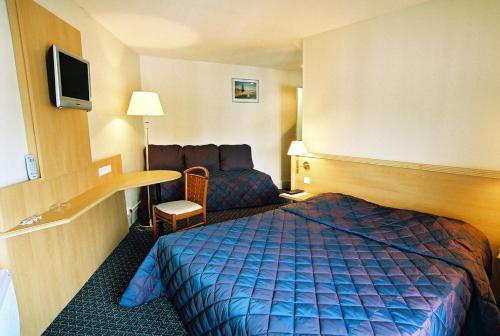 Кровать или кровати в номере Hotel Le Bourbon Pau Centre