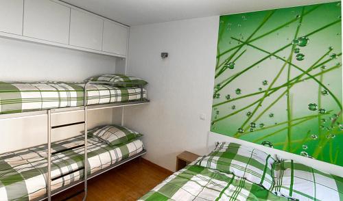 two bunk beds in a room with a green wall at Apartments Bohinjskih 7 in Bohinj