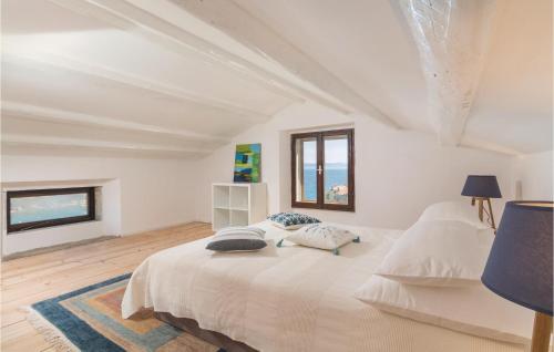 a white bedroom with a bed with two pillows on it at Awesome Home In Labin With Kitchen in Labin