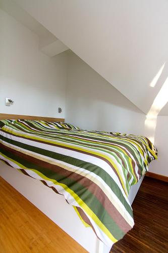 a bed with a colorful blanket on it in a room at Apartments Bohinjskih 7 in Bohinj