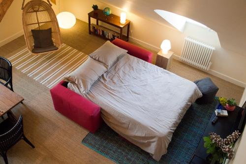 a bedroom with a bed and a red couch at Les Appartements d'Alexandre in Le Palais
