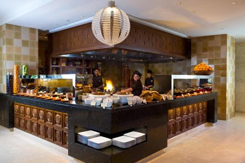 a group of people behind a counter in a restaurant at The Leela Palace Bengaluru in Bengaluru