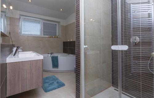 uma casa de banho com um chuveiro, um lavatório e uma banheira em Awesome Home In Vrsi With 5 Bedrooms, Wifi And Outdoor Swimming Pool em Vrsi