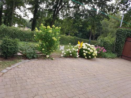 a bunch of flowers on a brick walk way at Ferienwohnung Siebmann in Neuruppin