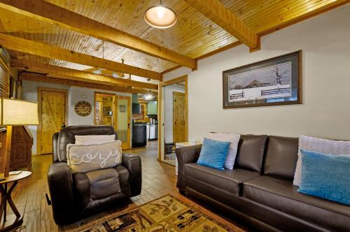 a living room with a leather couch and blue pillows at The Robins Nest with hot tub in Pigeon Forge
