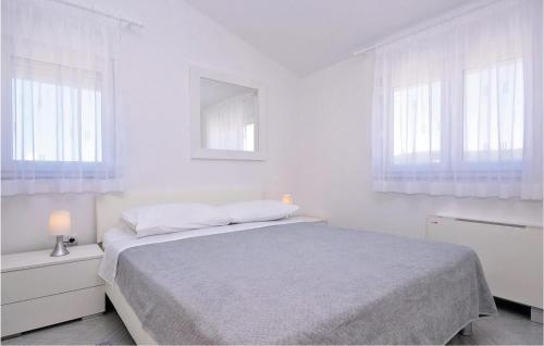 a white bedroom with a bed and two windows at 1 Bedroom Cozy Apartment In Bibinje in Bibinje