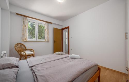 a bedroom with two beds and a chair and a window at Amazing Apartment In Porec With 2 Bedrooms And Wifi in Poreč